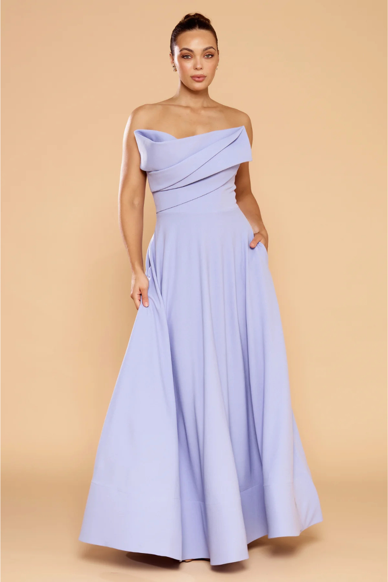 Woman wearing a light purple off-shoulder gown against a beige background