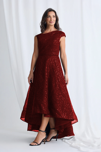 Woman wearing a burgundy lace dress against a white background