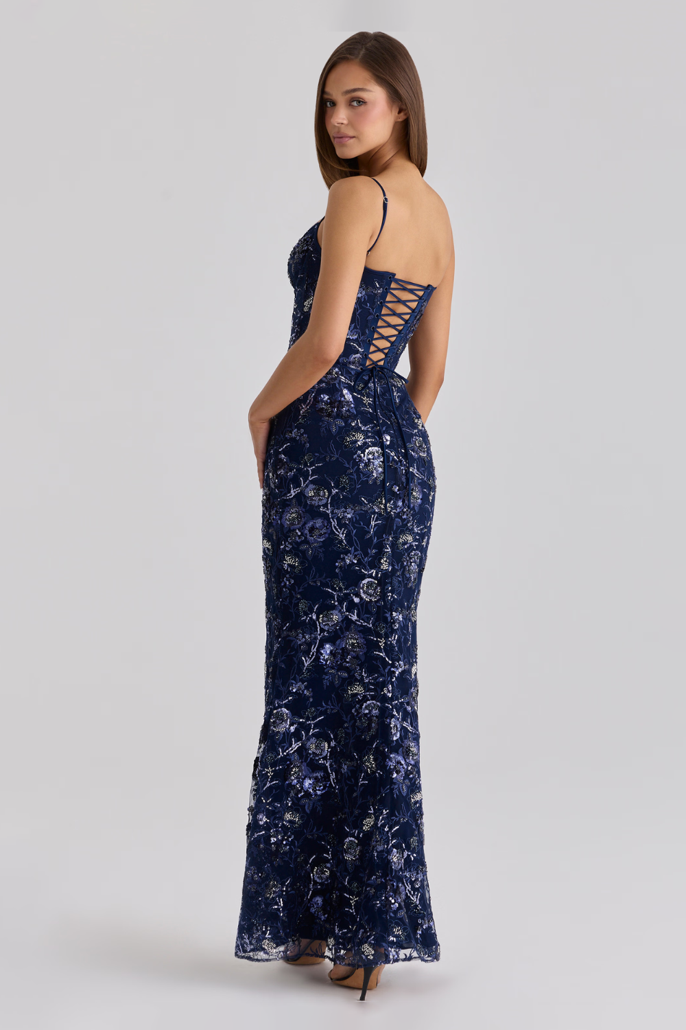 Woman wearing a navy blue floral lace dress on a white background