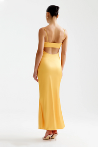 A model wearing a yellow dress with a straight neckline, thin adjustable straps, and a low open back, viewed from the back.